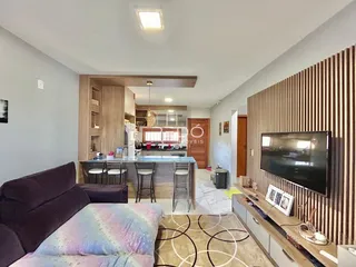 Sala de estar com cozinha aberta e parede de destaque em imóvel no Brasil.