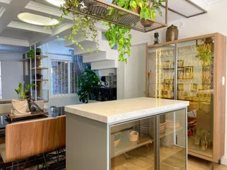 Ambiente interno com ilha de cozinha e escadaria em um imóvel.