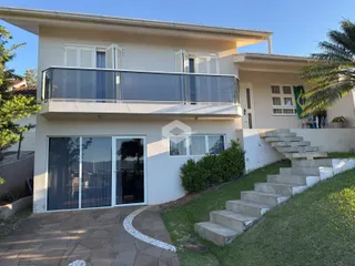 Fachada de uma residência em Lajeado, Brasil, com jardim e acesso por escadaria.