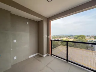 Vista da varanda com grade de segurança e paisagem.