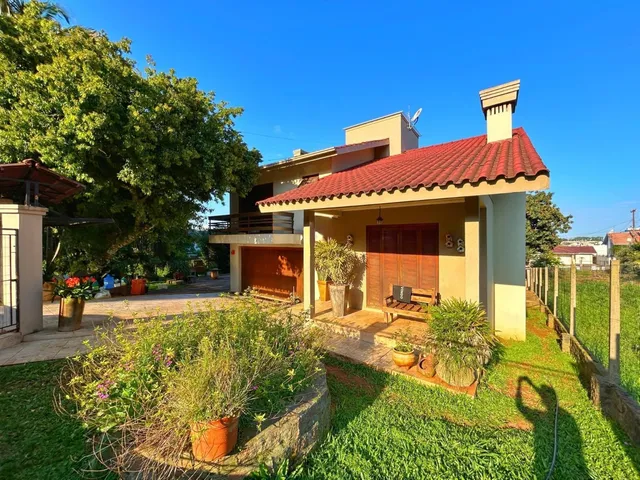 Fachada de uma residência em Lajeado, Brasil, apresentando um telhado de telhas vermelhas e jardim frontal.