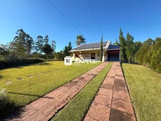 Foto da fachada de uma casa com jardim e caminho de tijolos em Lajeado.