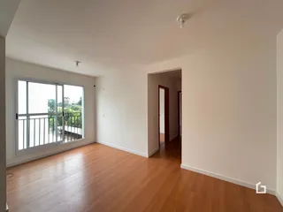 Sala de estar com piso de madeira clara e vista para o exterior.