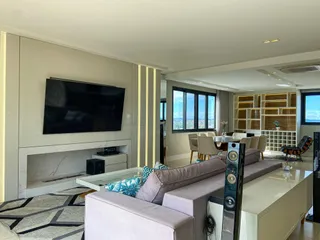 Sala de estar moderna com sofá grande e lareira em ambiente com vista.