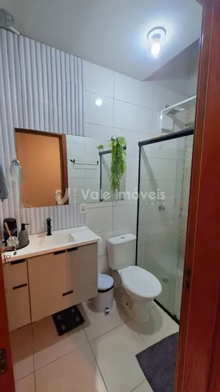 Foto de um banheiro com piso cerâmico e box de vidro.