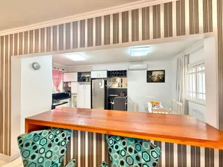 Foto de uma sala de jantar com móveis de madeira e decoração listrada.
