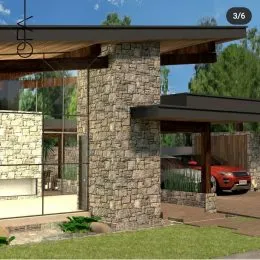 Fachada de uma residência com estrutura de pedra e área externa gramada.