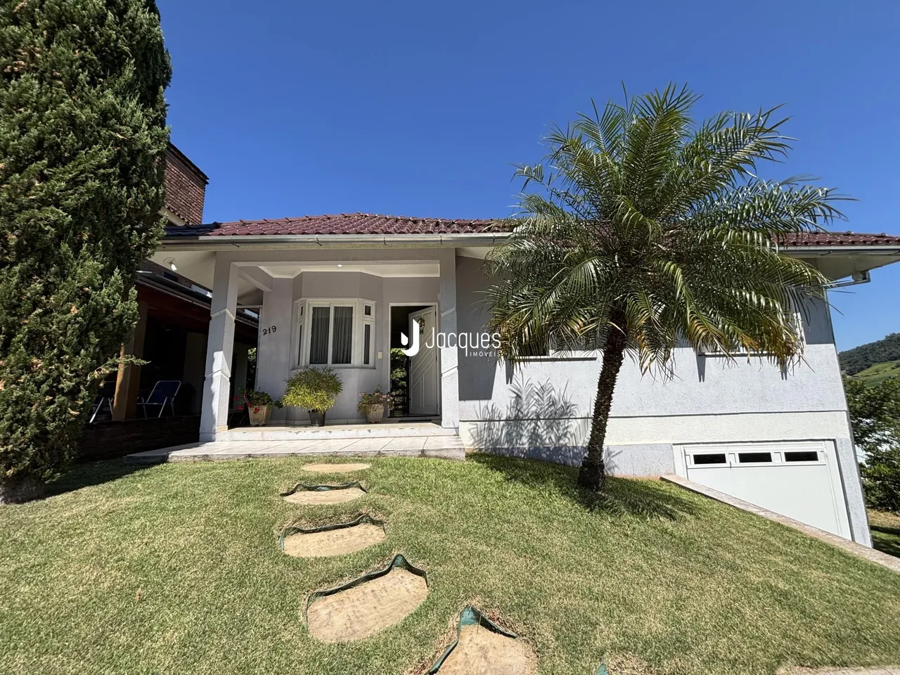 Fachada de uma residência em Lajeado, Brasil, com jardim gramado e palmeira.