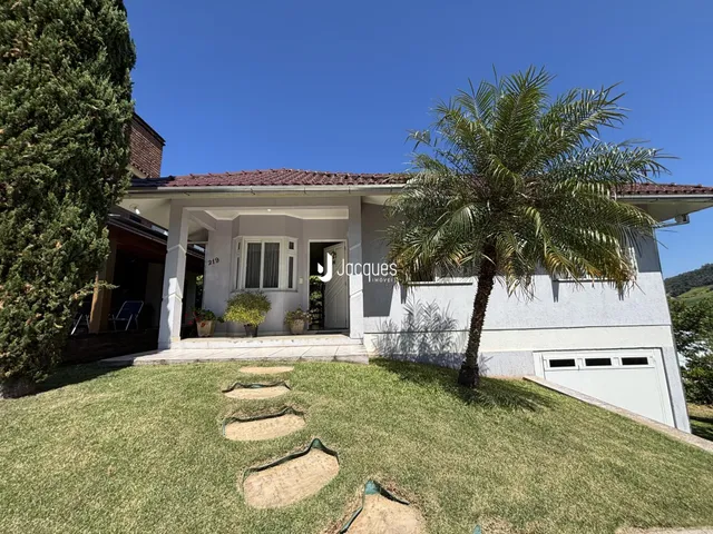 Fachada de uma residência em Lajeado, Brasil, com jardim gramado e palmeira.