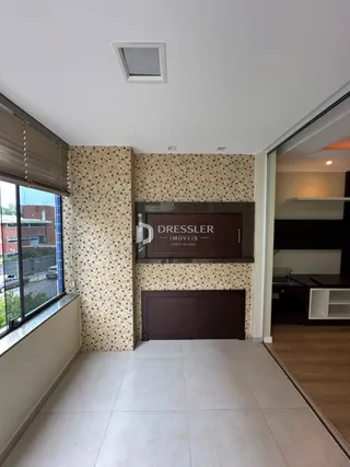 Um corredor interno com parede decorada e passagem para outra área.