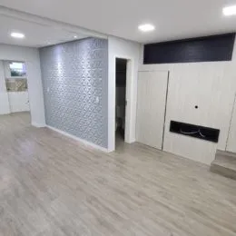 Foto de um ambiente interno com piso claro e parede texturizada.