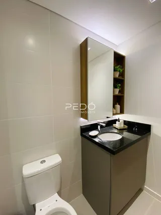Foto de um banheiro moderno com azulejos brancos e bancada escura.