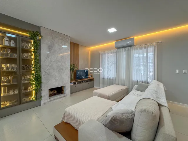 Sala de estar moderna com lareira e estantes de madeira.