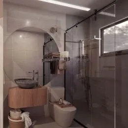 Banheiro com box de vidro e bancada de madeira.