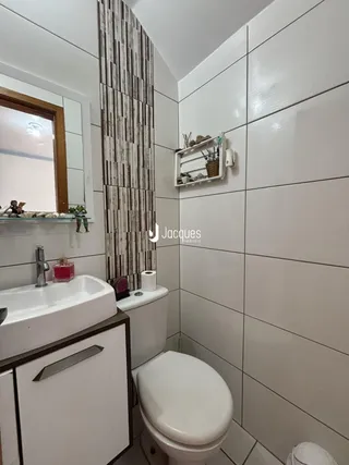 Um banheiro moderno com azulejos brancos e detalhes em madeira.