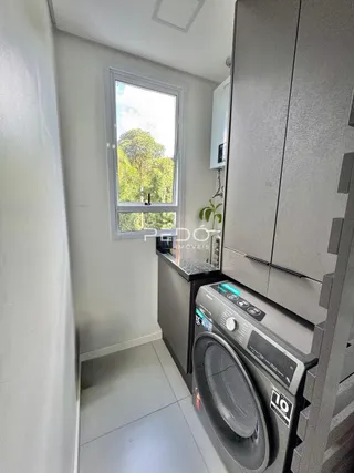 Vista interna de um ambiente com janela e máquina de lavar roupa.
