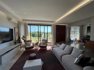 Sala de estar ampla com vista para o exterior e grandes janelas.