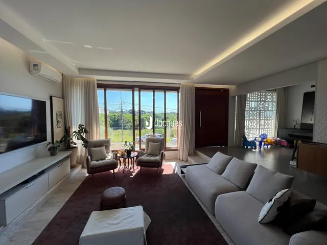 Sala de estar ampla com vista para o exterior e grandes janelas.