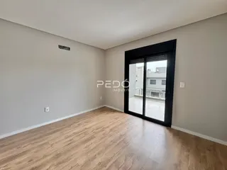 Sala de estar com piso de madeira clara e paredes brancas.