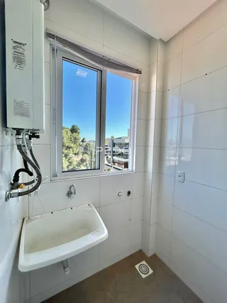 Foto de um banheiro interno com janela e banheira branca.