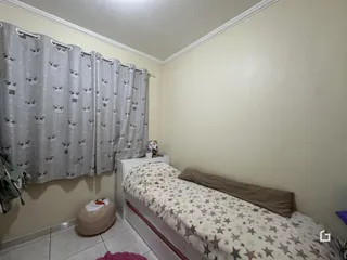 Quarto interno com cama e cortinas na janela.