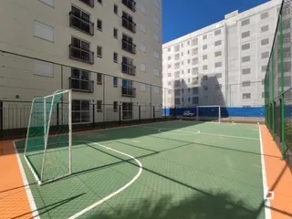 Vista externa de uma quadra esportiva com marcações verdes.