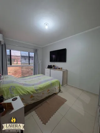 Quarto com cama e televisão em um imóvel.