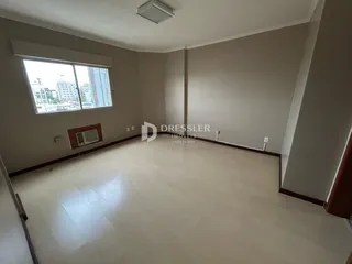 Ambiente interno de uma sala com piso claro e paredes neutras.