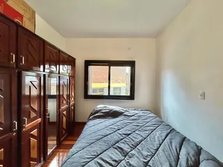Quarto com armário de madeira e janela.