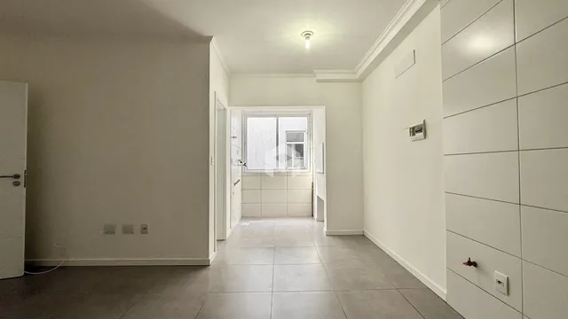 Hall de entrada com piso claro e paredes brancas em uma residência.