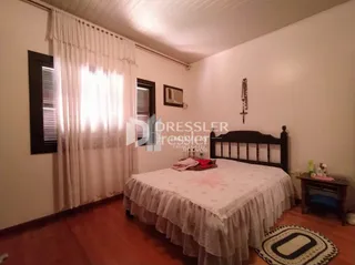 Foto de um quarto com cama e cortinas em uma residência.