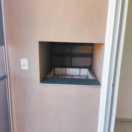 Nicho embutido na parede com estrutura de prateleiras.