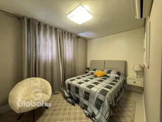 Quarto com cama e cortinas em um ambiente claro.