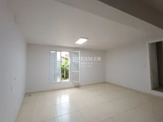 Uma sala interna com piso de cerâmica e janela.