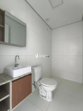 Foto de um banheiro moderno com revestimento branco e piso claro.