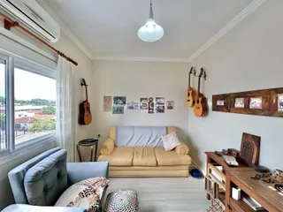 Sala de estar com janela e sofá em um imóvel no Brasil.