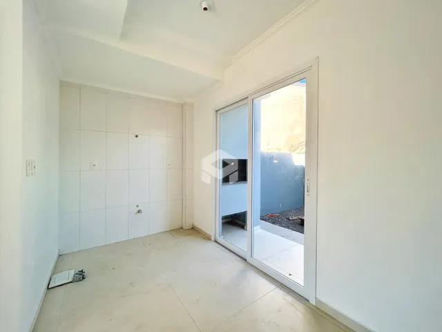 Vista interna de um corredor com paredes brancas e piso claro.
