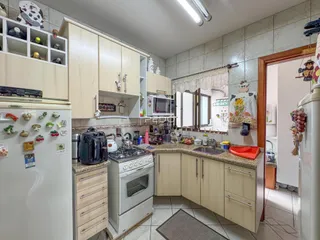 Foto de uma cozinha com armários de madeira clara e bancadas de granito.