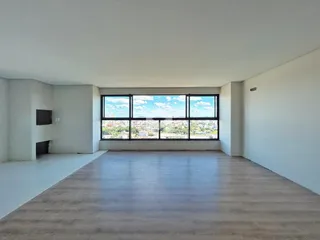 Sala de estar ampla com grande janela oferecendo vista da cidade.