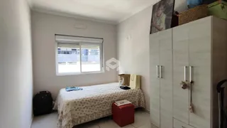 Quarto com janela e armário em ambiente claro.