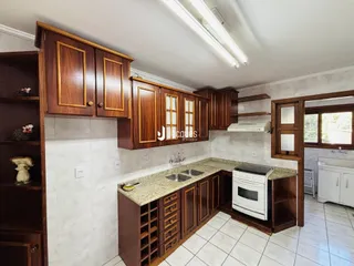 Cozinha com armários de madeira e revestimento branco.