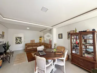 Sala de estar com sofá e mesa de jantar em um apartamento.
