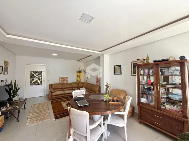 Sala de estar com sofá e mesa de jantar em um apartamento.