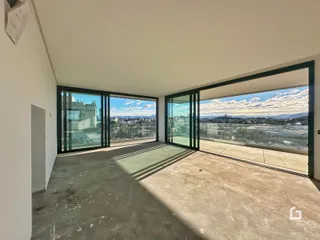 A sala de estar possui grandes portas de vidro com vista para a paisagem.