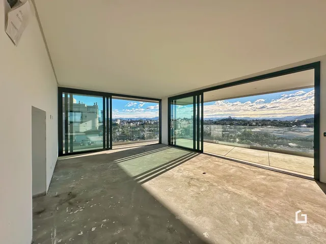 A sala de estar possui grandes portas de vidro com vista para a paisagem.