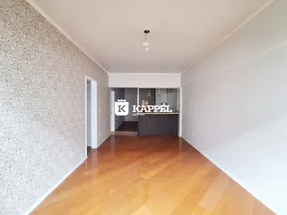 Hall de entrada com piso de madeira e parede decorada.
