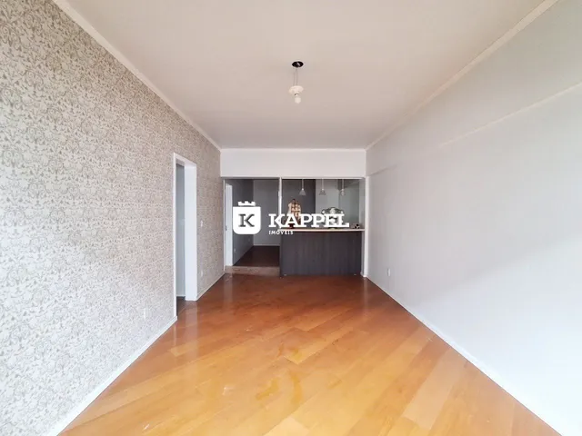 Hall de entrada com piso de madeira e parede decorada.