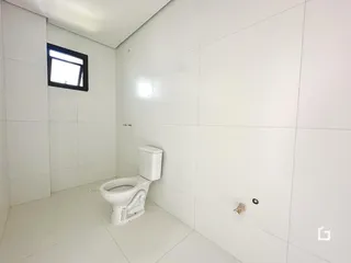 Um banheiro com paredes brancas e piso claro.