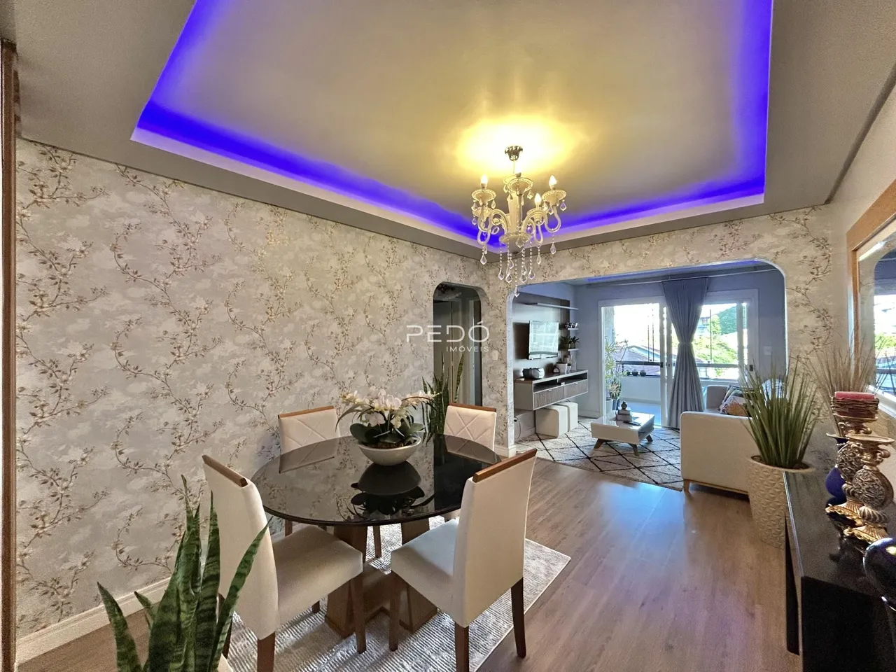 Sala de estar com decoração moderna e piso de madeira.