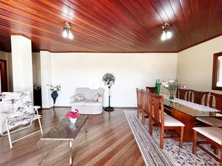Sala de estar com piso de madeira e móveis.